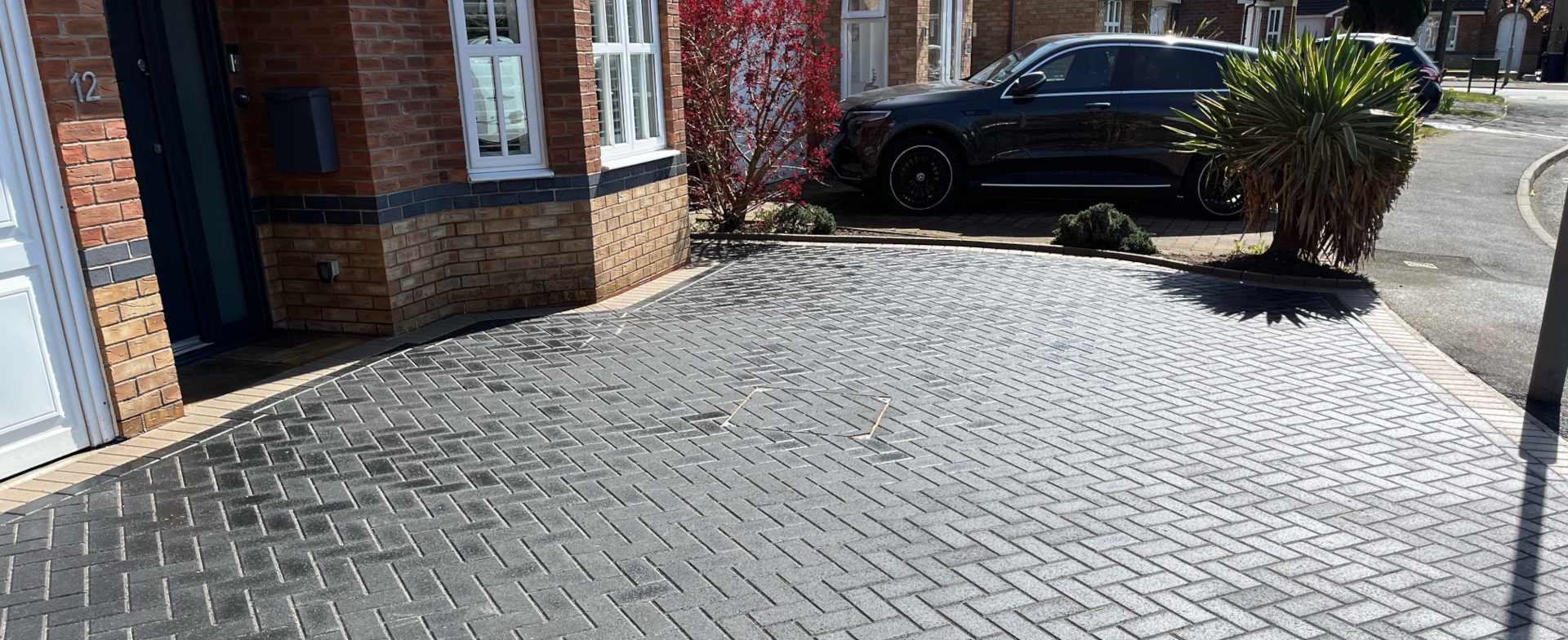 New charcoal grey block paved driveways and car parking area.